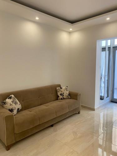 a living room with a brown couch with two pillows at Ghadira Bay Retreat by MA Properties in Is-Sellum