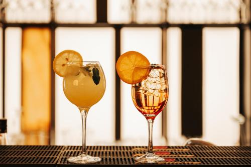 two glasses with orange slices in them on a table at Grand Hotel Napoca in Cluj-Napoca