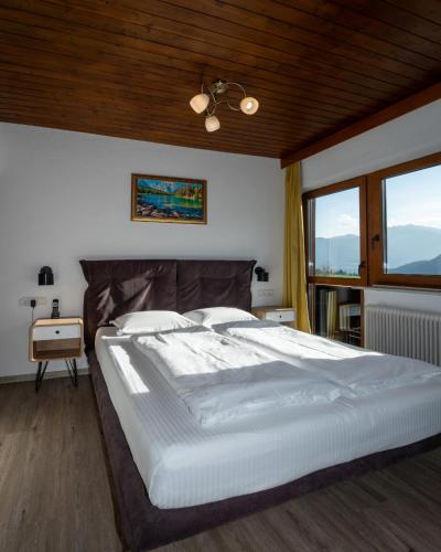a bedroom with a large bed with a wooden ceiling at Alpenhotel Edelweiss in Maurach