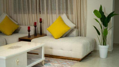 a living room with two yellow pillows on a couch at Appart Hôtel Golden Sky Home Café Restaurant & Spa in Beni Mellal