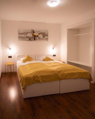 a bedroom with a large bed with a yellow blanket at Alpenhotel Edelweiss in Maurach