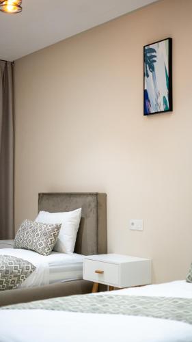 a white bedroom with two beds and a table at Appart Hôtel Golden Sky Home Café Restaurant & Spa in Beni Mellal