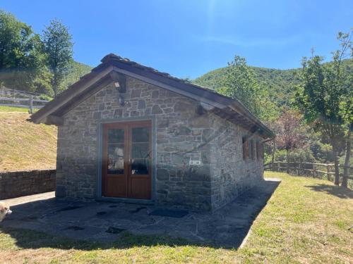 a small stone building with a wooden door at Agriturismo Le Roncacce in Abetone