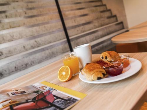 a breakfast plate of croissants and orange juice on a table at Ibis Styles Paris Place d'Italie - Butte Aux Cailles in Paris