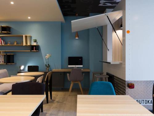 a restaurant with tables and chairs and a computer on the wall at Ibis Styles Paris Place d'Italie - Butte Aux Cailles in Paris