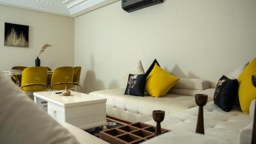 a living room with two couches and yellow pillows at Appart Hôtel Golden Sky Home Café Restaurant & Spa in Beni Mellal