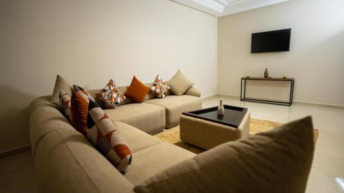 a living room with two couches and a tv at Appart Hôtel Golden Sky Home Café Restaurant & Spa in Beni Mellal