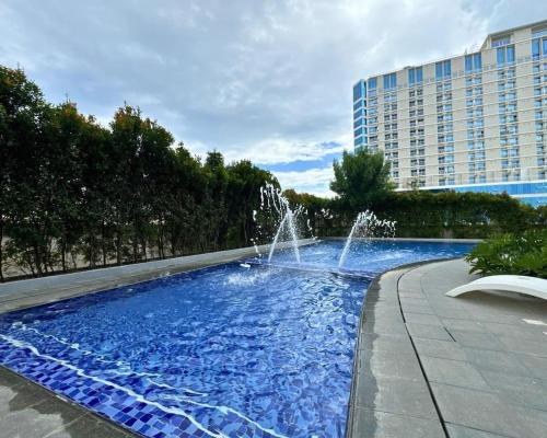 a fountain in a pool in front of a building at Aeon Tower Executive Suite in Davao City