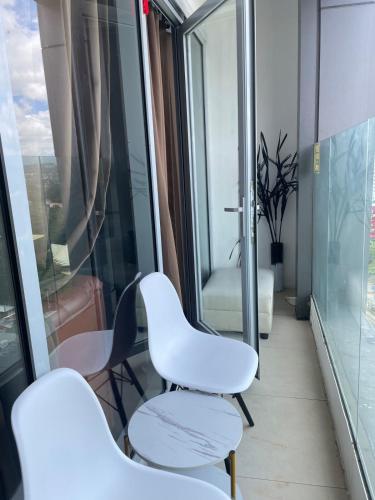 a room with two white chairs and a window at Aeon Tower Executive Suite in Davao City