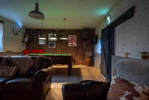 a living room with a pool table in a room at The Cottage at Barraston Farm in Balmore