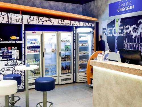a store with two refrigerators and a counter and chairs at ibis budget Osasco in Osasco