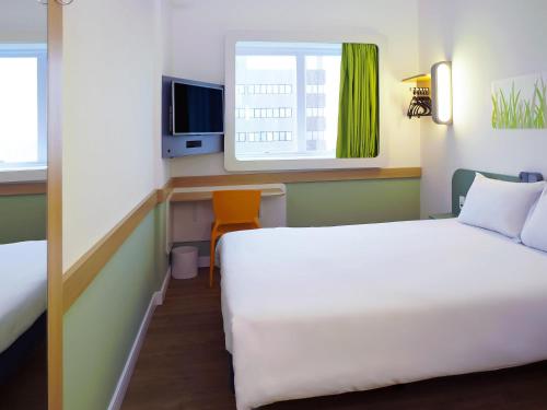 a hotel room with a bed and a window at ibis budget Osasco in Osasco