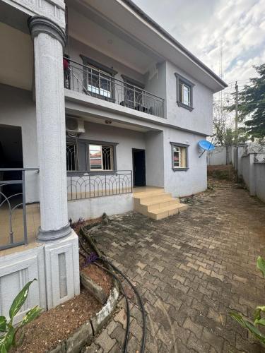 a white house with a porch and a balcony at Barry's Hilton extension in Abuja