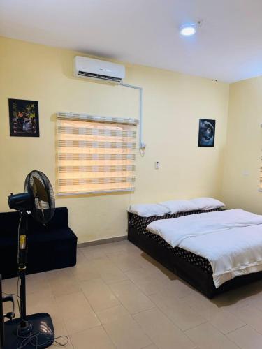 a bedroom with two beds and a fan at Barry's Hilton extension in Abuja