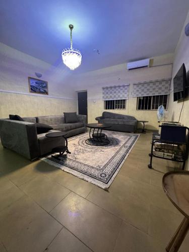 a large living room with couches and a rug at Barry's Hilton extension in Abuja
