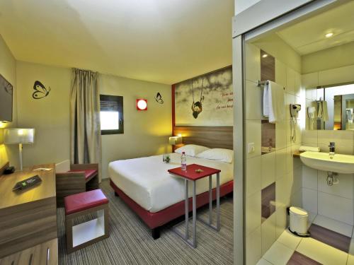 a hotel room with a bed and a sink at ibis Styles Castres in Castres