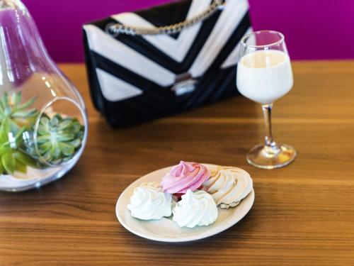a plate of whipped cream and a glass of milk at ibis Styles Castres in Castres