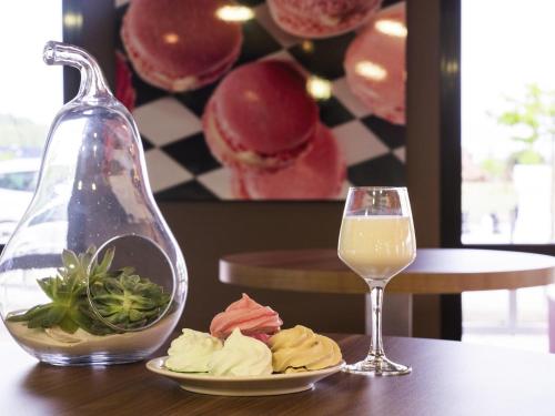 a plate of food and a glass of wine on a table at ibis Styles Castres in Castres