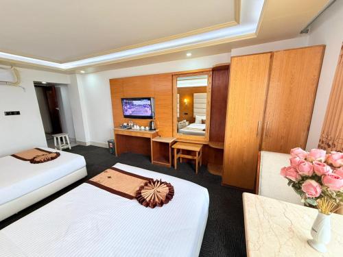 a hotel room with two beds and a television at The Ambassador Airport Hotel in Dhaka