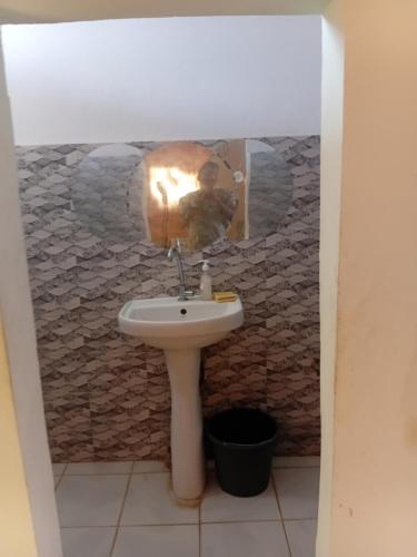 a bathroom with a sink and a picture of a man at Chez kriss auberge in Pikine