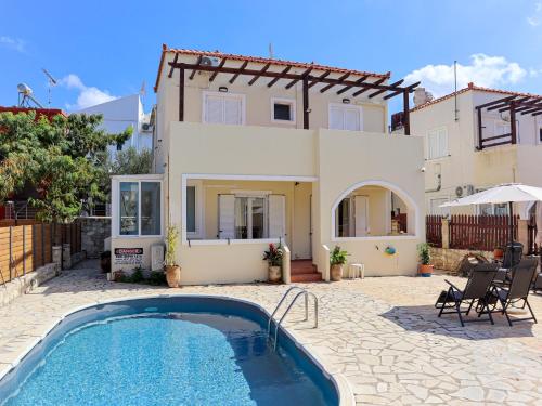 a villa with a swimming pool in front of a house at Naya Home - New listing! in Almirida