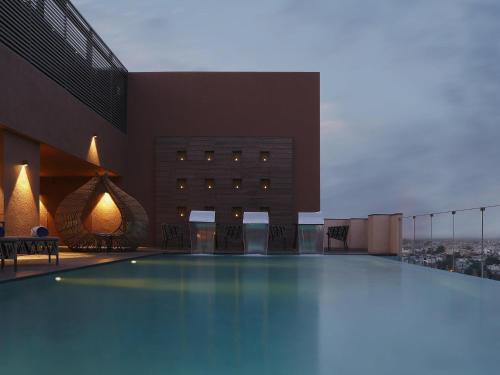 a swimming pool in the middle of a building at Novotel Lucknow Gomti Nagar in Lucknow