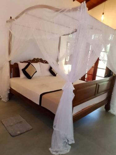a bedroom with a bed with a canopy at T N D House in Habaraduwa Central