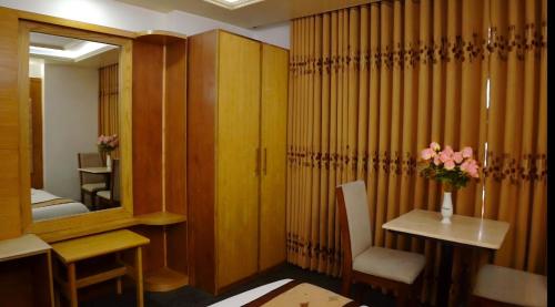 a bathroom with a mirror and a table with a vase of flowers at The Ambassador Airport Hotel in Dhaka