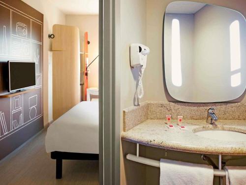 a bathroom with a sink and a mirror at ibis Paranagua in Paranaguá