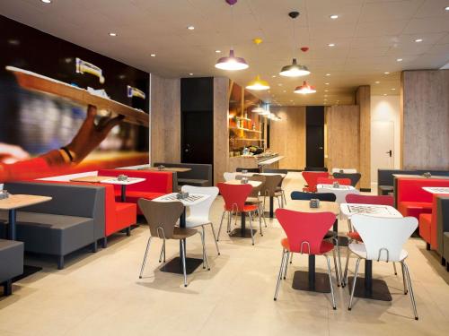 a restaurant with red and white tables and chairs at ibis Paranagua in Paranaguá