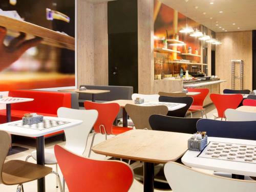a restaurant with tables and chairs and a laptop at ibis Paranagua in Paranaguá