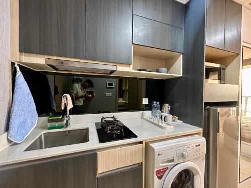 a kitchen with a sink and a washing machine at Gold Coast Apartment PIK Luxury Sea View by stay with E in Jakarta