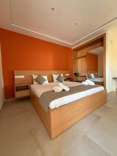 a bedroom with a large bed with orange walls at Hôtel Everest, Séjour Balnéaire à Saïdia in Saidia 