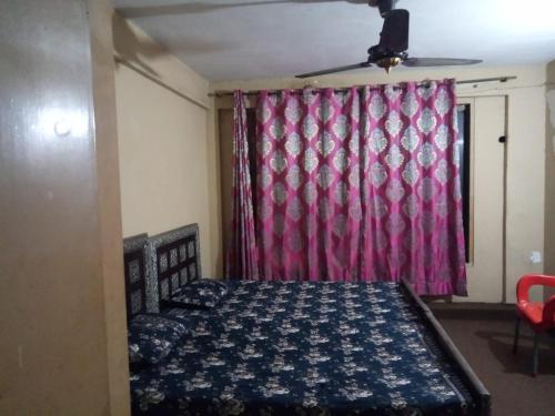 a bedroom with a bed and a red curtain at Usmania hotel rooms 