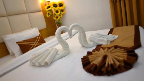 two swans made out of fondant sitting on a bed at The Ambassador Airport Hotel in Dhaka