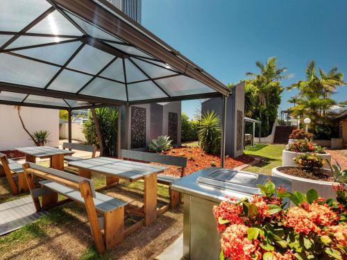 a patio with a table and chairs under an umbrella at Novotel Surfers Paradise in Gold Coast
