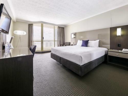 a hotel room with a large bed and a window at Novotel Surfers Paradise in Gold Coast