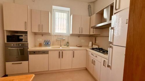 a kitchen with white cabinets and a sink at Stylish Stay Overlooking Fountain Square in Baku
