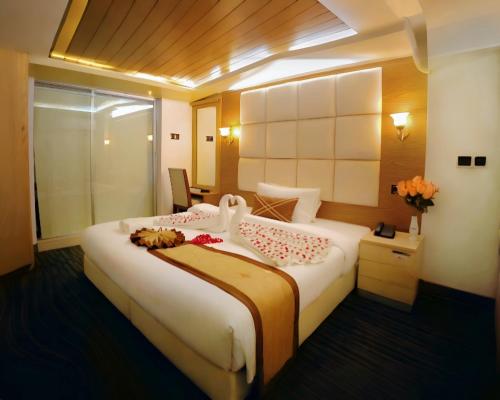 a bedroom with a large white bed in a room at The Ambassador Airport Hotel in Dhaka