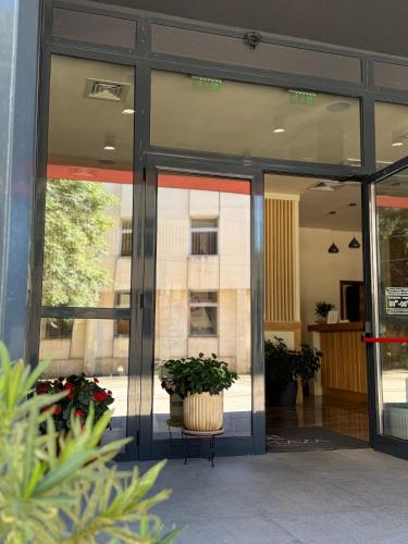 a glass door of a building with a potted plant at City Plaza in Botevgrad