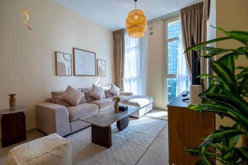a living room with a couch and a table at Modern 2BR Haven - Chic Serene Escape in Abu Dhabi