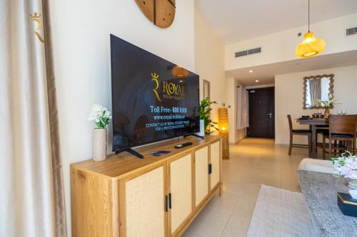 a living room with a flat screen tv on a entertainment center at Modern 2BR Haven - Chic Serene Escape in Abu Dhabi