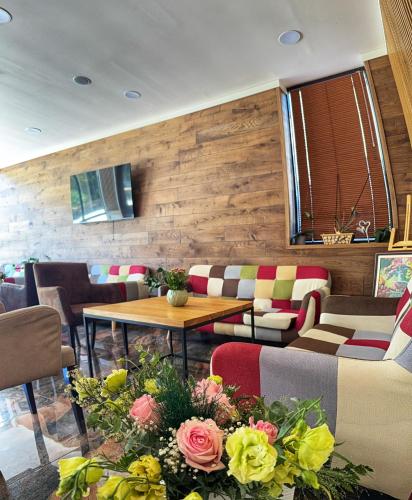 un restaurante con mesa, sillas y flores en City Plaza, en Botevgrad