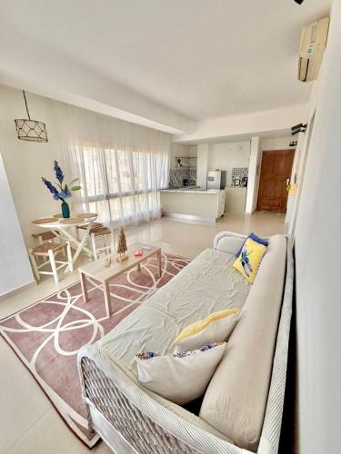 a living room with a bed and a table at beachfront apartment with pool in Porlamar in Porlamar