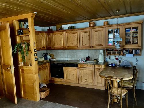 a kitchen with wooden cabinets and a table with chairs at Parterre-Wohnung im Zentrum in Gstaad