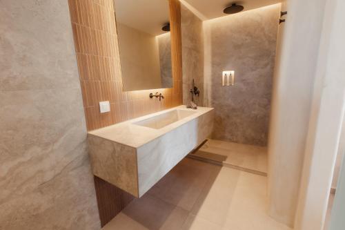 a bathroom with a sink and a mirror at Aerostay Mykonos in Mýkonos City