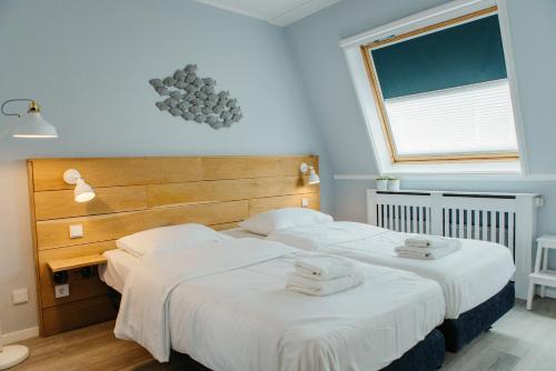 ヘーグにあるHavenwoning geschakeld | 6 personen - Boutique Parc Pharshoekeの白いシーツ2枚が備わるベッドルームのベッド2台