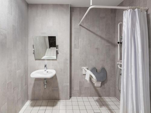 a bathroom with a sink and a shower at B&B Hotel Mönchengladbach in Mönchengladbach