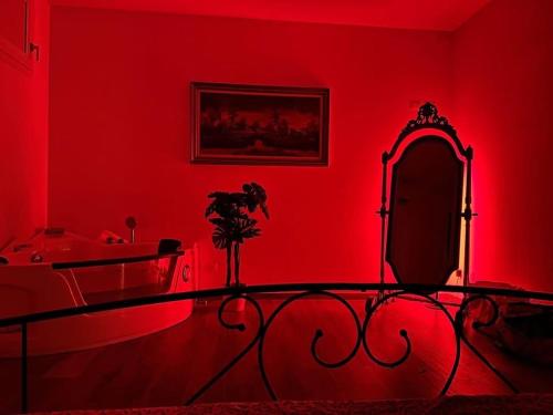 a red room with a bed and a mirror at Villa Alexander,Suite Imperiale con idromassaggio in Trarivi