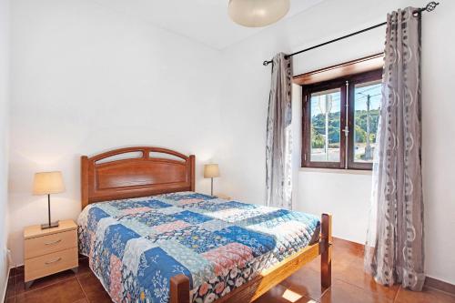 a bedroom with a bed and a window at Casinha Da Aldeia in Cela Velha